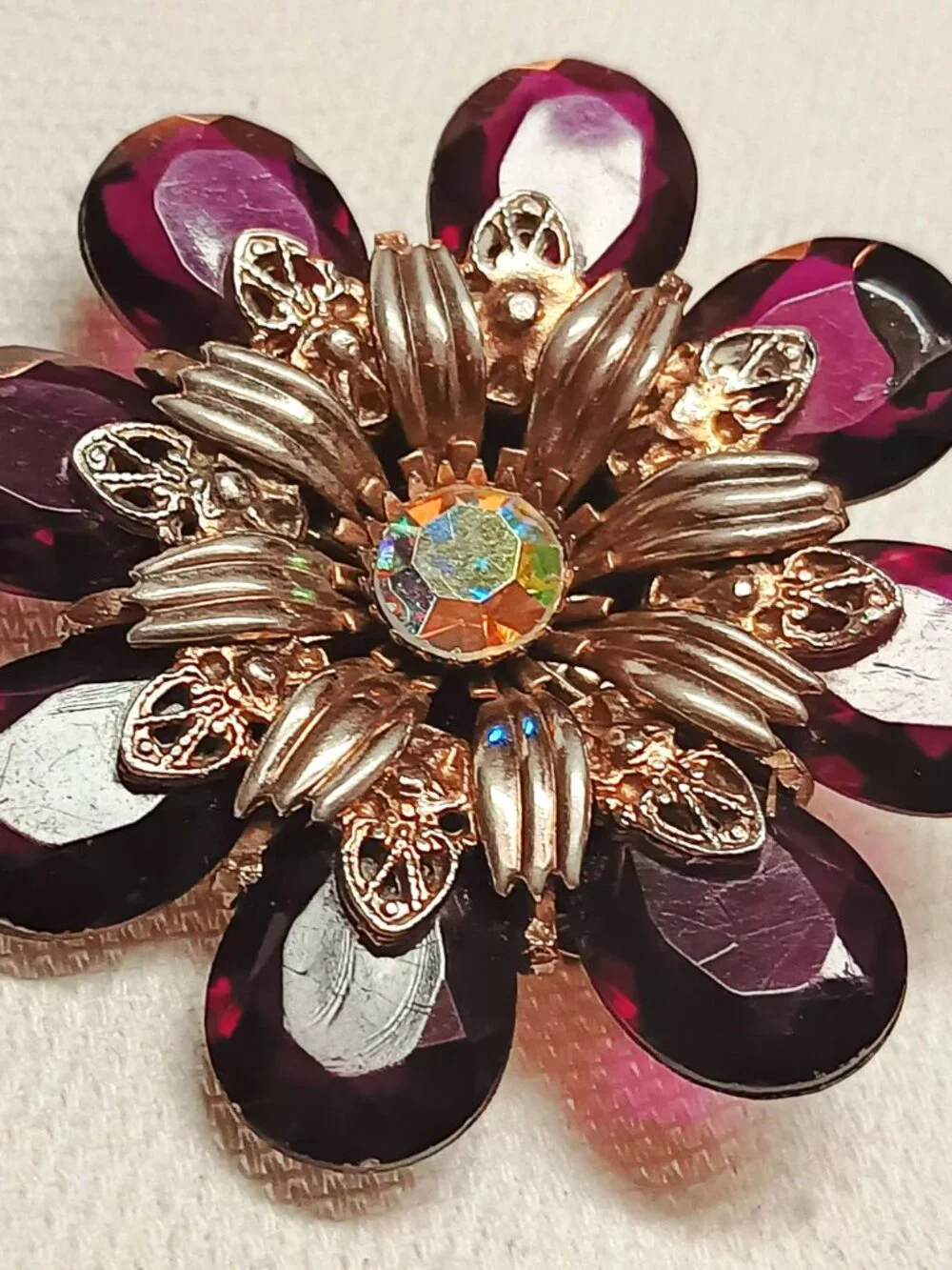 Vintage ruby lucite brooch with aurora borealis central rhinestone.